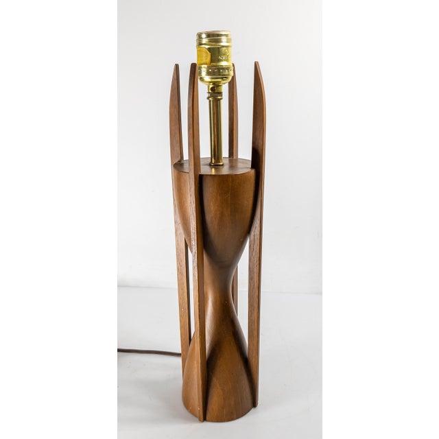 We are selling this cool Mid-Century Modern table lamp. This lamp has cool form with hourglass body with vertical elements...