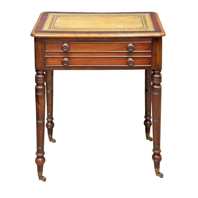 A fine diminutive English library table or writing desk from the 19th century, featuring a moulded rectangular top with...
