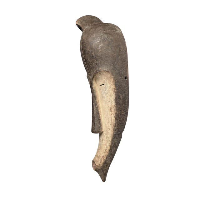 Superb vintage Fang mask carved from a single piece of heavy wood, featuring an elongated heart-shaped face rendered in...