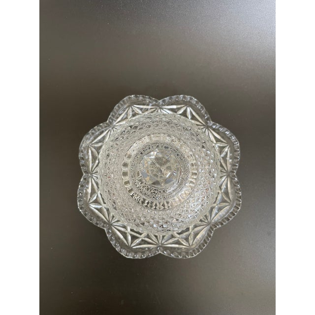 This Mid-Century butter dish was produced by Fostoria Glass for Avon. The set features an ornate domed cover with star &...