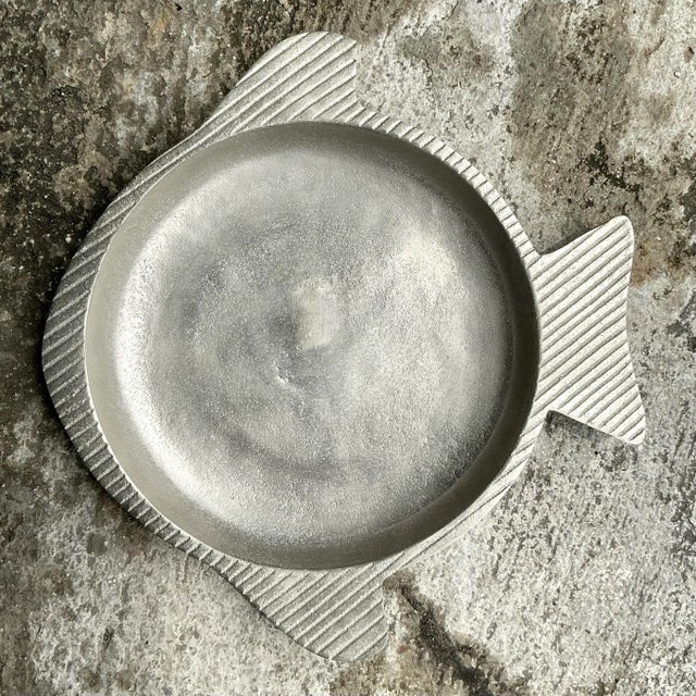 This Vintage Coastal Etched Pewter Fish Tray brings seaside charm to your table. With intricate fish designs and a...