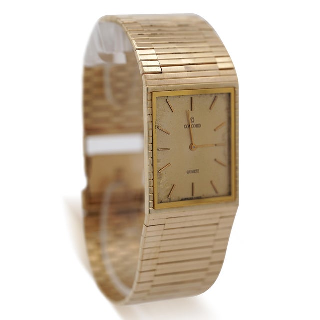 Vintage Concord rectangular watch features a champagne dial with gold baton markers and gold hands in a rectangular 14K...