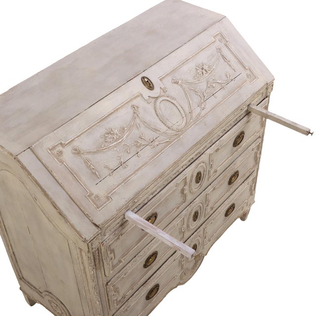 An elegant desk, the carved case features a fall-front writing surface that opens to reveal six small interior drawers....