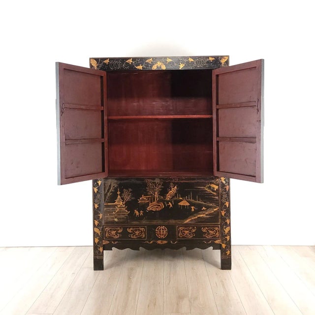 A vintage Chinese gilt and black lacquered wedding cabinet, circa 1960.