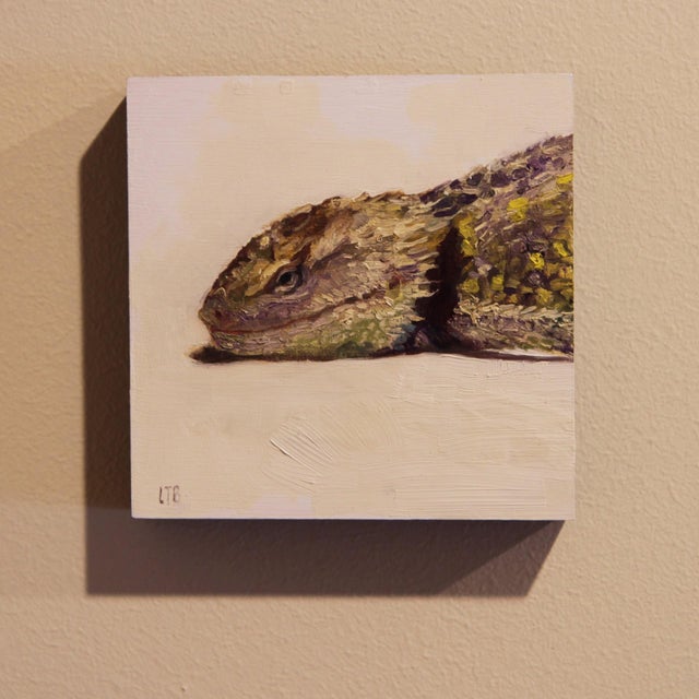 This oil painting features a close-up view of a lizard, rendered with meticulous attention to detail and texture. The...