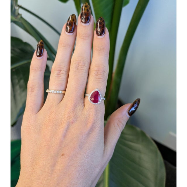 A 4.3-carat red madagascar ruby pear sits at the centre of this solid 14K white gold ring, framed by thirty-seven earth-...