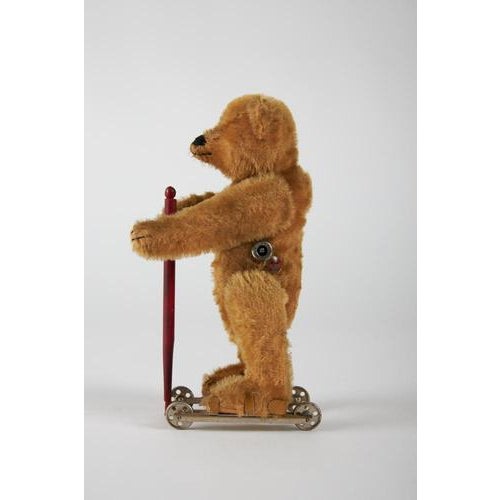 Rare mechanical bear with wool and wood stuffing, button eyes, tin skates, and a wooden stick. Original manufacturer's...