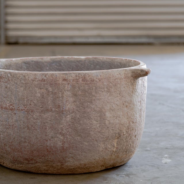 Monumental sandstone vessel with decorative handle details.