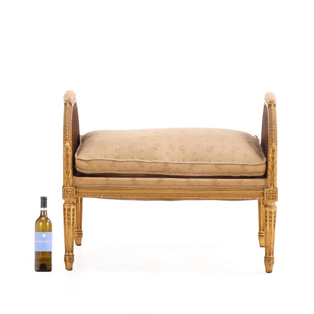 A handsome French Louis XVI style giltwood and caned bench dating to circa 1900. Elegantly proportioned, the bench...