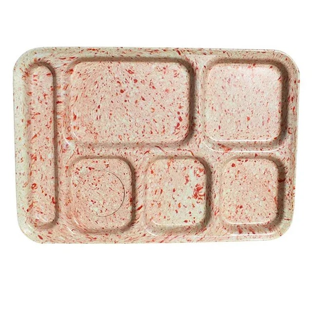 A set of four hard plastic vintage lunch trays. This set of trays is decorated with confetti or splatter ware in red and...