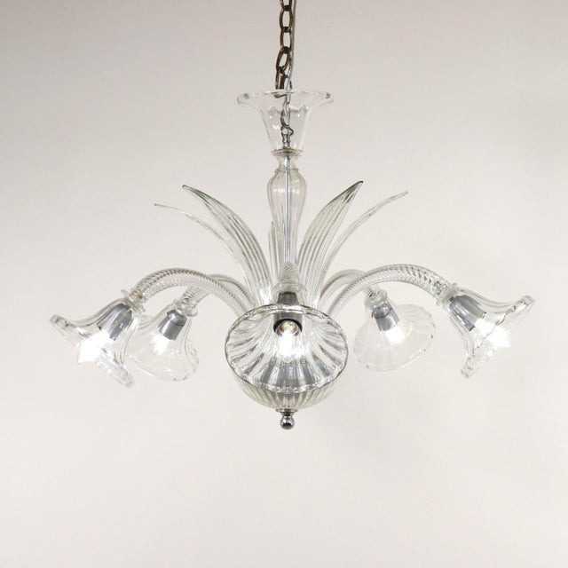This tasteful mid-century modern Murano chandelier has five scroll arms, a bulbous center column with sprouting leaf...