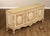 Decorative French Provincial style sideboard featuring an elegant cream-painted finish with antiqued distressing and...