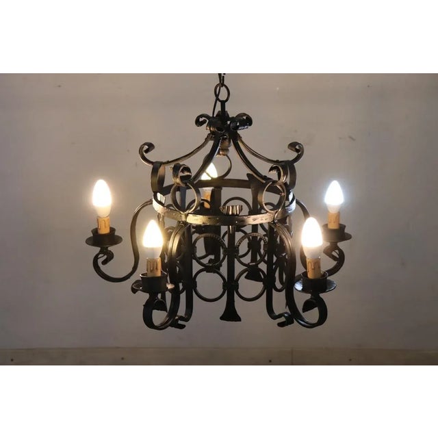 This special chandelier, made entirely of black iron, is a striking piece from the first half of the 20th century. Its...
