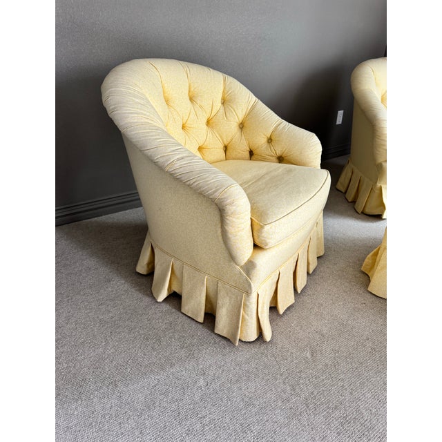These are classic tufted barrel chairs with a rounded, enveloping back, button tufting on the interior, rolled arms, and a...