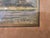 This framed landscape artwork presents a serene, atmospheric countryside scene in a narrow vertical format. The...