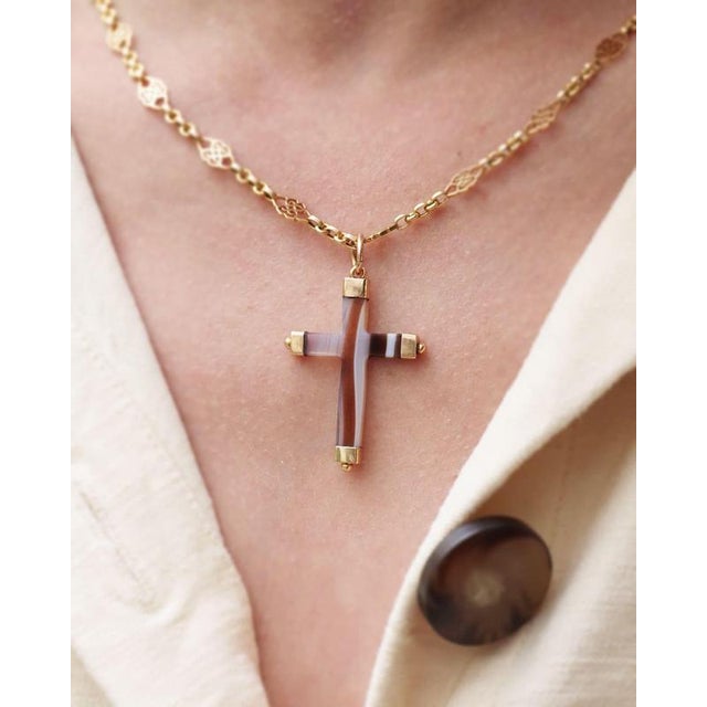 Antique agate cross pendant in 18 karat gold. Antique cross carved from a zoned agate with white, brown, and translucent...