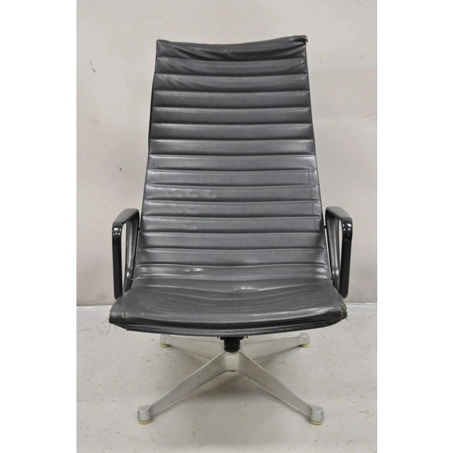 Vintage Herman Miller Charles and Ray Eames Design Swivel Aluminum Group Black Vinyl Arm Chair. Circa Late 20th Century....