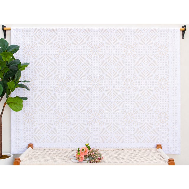 A lightweight cotton coverlet from Western India, beautifully adorned with intricate handcrafted appliqué cutwork. The...