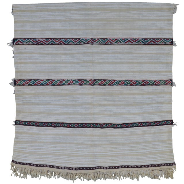 Vintage wedding blanket handmade in the High Atlas Mountains of Morocco. Featuring alternating stripes of wool fringe and...