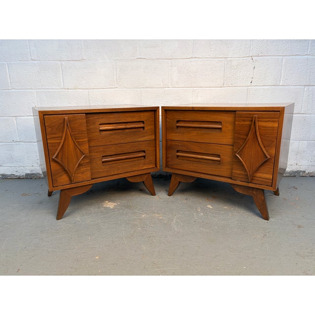 Striking pair of mid-century modern nightstands crafted from richly grained walnut and accented with bold sculptural...