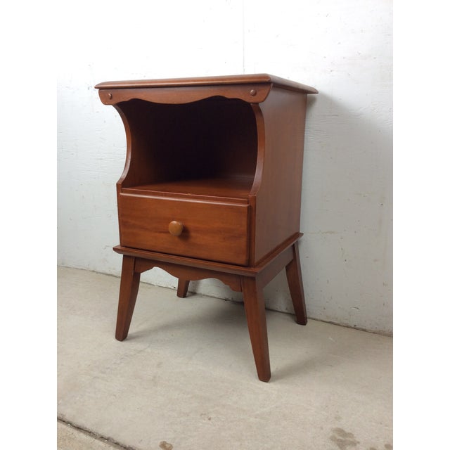 This mid century American colonial revival nightstand features hardwood construction, original maple finish, single...