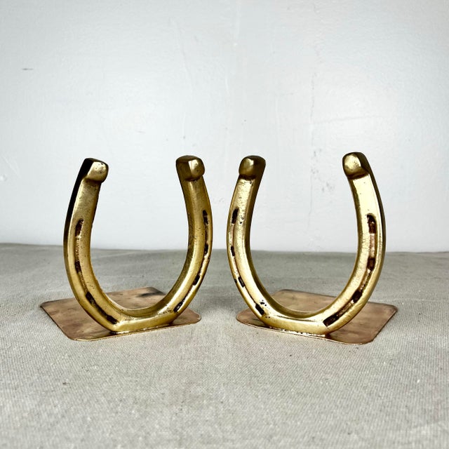Vintage mid century pair of brass horseshoe bookends. Perfect equestrian accent for your book shelf.