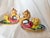 Pair of vintage 1950s Italian majolica chambersticks, each featuring a sculptural griffin handle with a detailed lion-like...