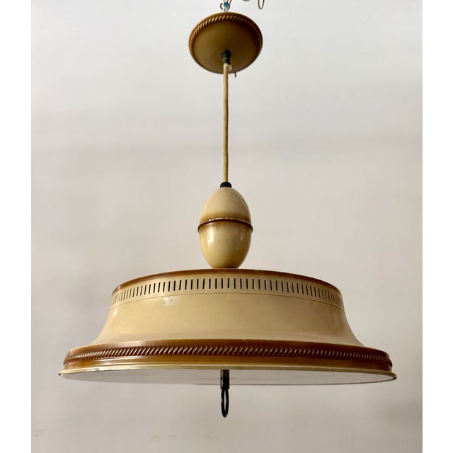 This cool vintage chandelier features a dramatic saucer-form silhouette crafted in painted tole metal with warm almond...