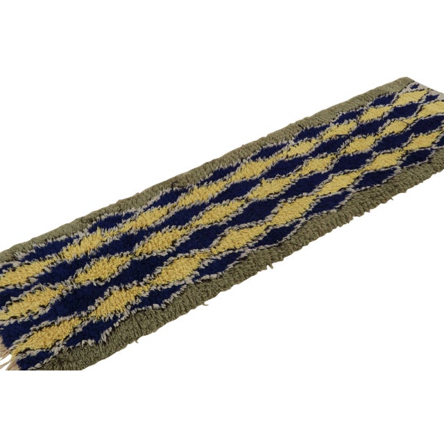 Hand-knotted in wool circa 1950-1960, this 2x8 vintage Moroccan runner rug with diamond geometric patterns on a navy blue...