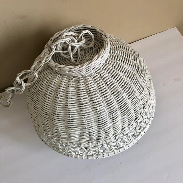 A mid century white wicker hanging swag light.