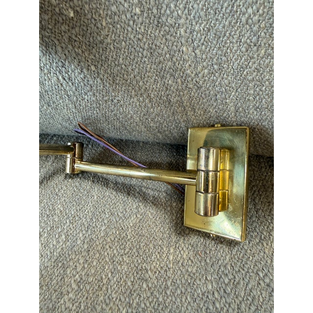 Elegant pair of mid-century modern wall sconces featuring sculptural double cone shades in white, mounted on polished...