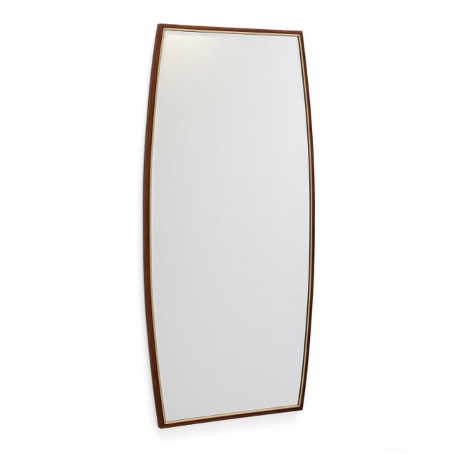 A pair of walnut and brass boat shaped mirrors with beveled glass by the Hoke Wood Products Company. The tends of the...