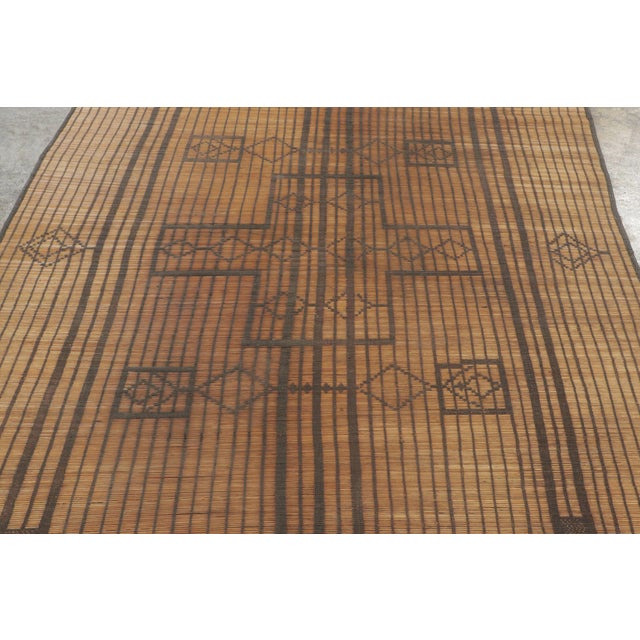 This vintage Moroccan mat is a primitive 6x7 Tuareg work from the nomadic tribe of the same name. Handwoven with reeds and...