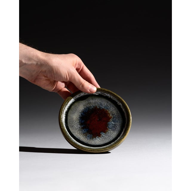 A refined duo of studio ceramic plates by German ceramic artist Barbara Stehr. Layered mineral glazes in earthy greens,...