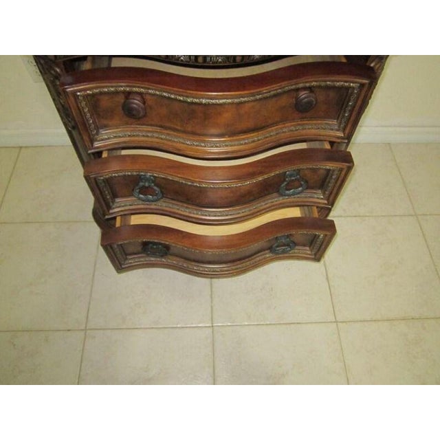 The product described is a stylish and luxurious nightstand with a marble top and carved wood detailing in a dark tone...