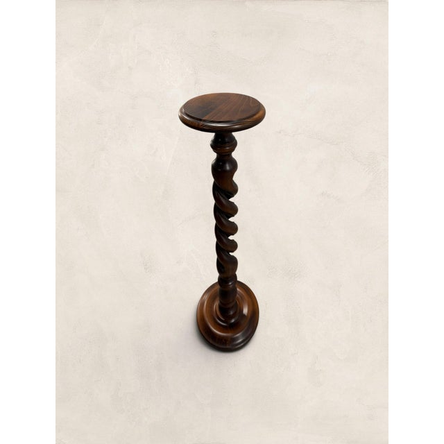 A striking English oak plant stand dating to circa 1970, featuring an open barley twist column set between a turned...