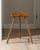 Sculptural vintage tripod stool crafted from solid beech, featuring a carved saddle-form seat, tapered legs, and slender...