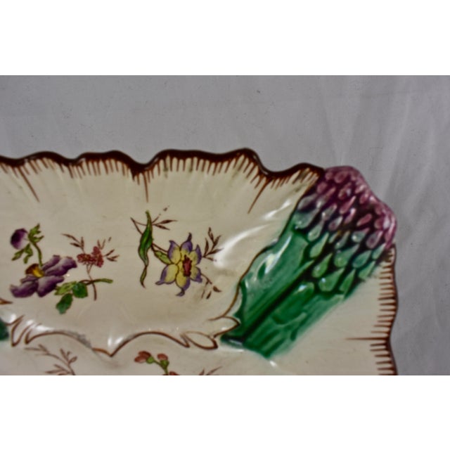 A French earthenware, hand-painted square asparagus plate, circa 1890-1910. Majolica glazed asparagus tips are shown at...