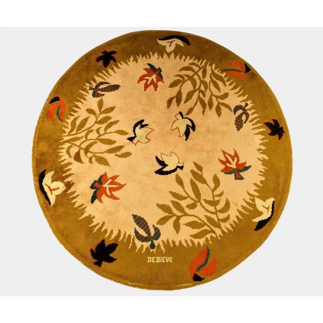 Hand-knotted in wool, this 9x9 vintage French circular rug by Robert Debiève (1926–1994) is a charming example of mid-...