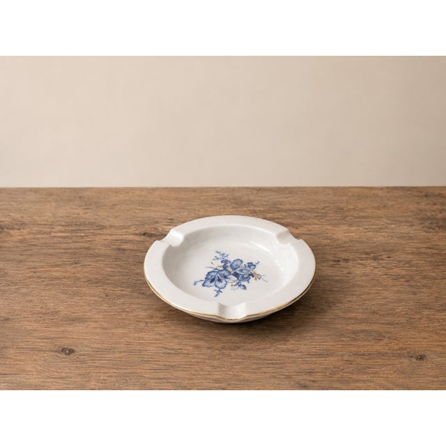 An elegant vintage ashtray in authentic Meissen hard-paste porcelain, featuring a delicate hand-applied blue floral motif...