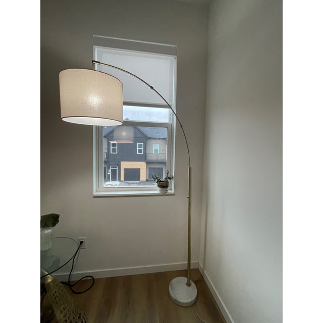 Adjustable arc lamp. Three levels of brightness. Brass body, linen shade, marble base.