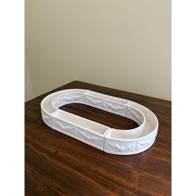 A gorgeous neoclassical style white porcelain Venetian Garden centerpiece made up of four long low vases that form an oval...