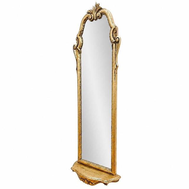An elegant mid-century Italian giltwood pier mirror featuring an arched crest adorned with a hand-carved acanthus leaf...