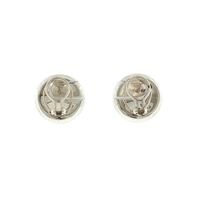 A late 20th-century pair of sterling silver thumbprint earrings designed by Elsa Peretti for Tiffany & Co. They are round...