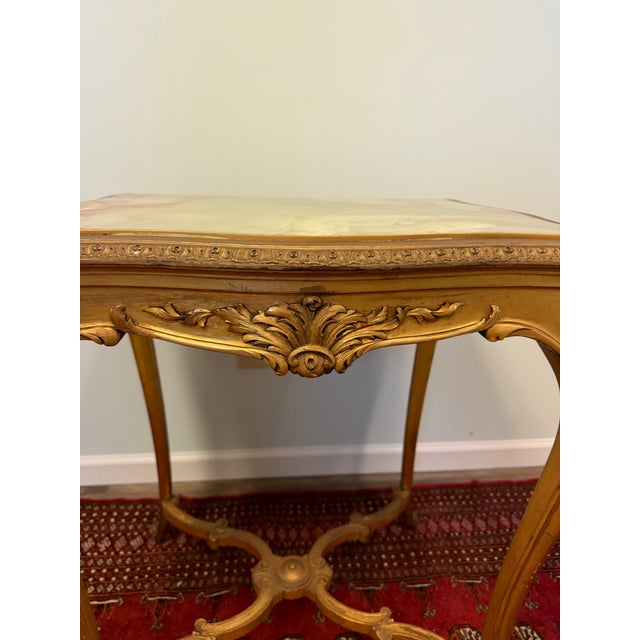 Exceptional French Louis XVI-style occasional table with an ornate carved giltwood frame and striking natural green onyx...
