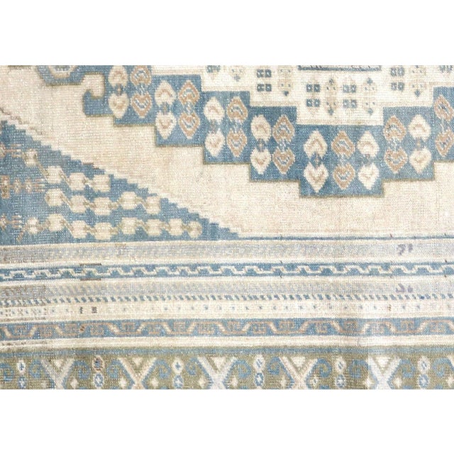 A vintage Turkish Oushak measuring 5'5" x 8'8", hand-woven with wool on wool foundation. This piece displays the region's...