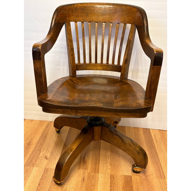 Bring a timeless presence to your workspace with this exceptional early 20th-century vintage banker's chair. A beautiful...
