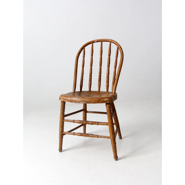 Antique farmhouse-style Windsor dining chair dating to the late 19th century. Crafted in wood, the chair features a...