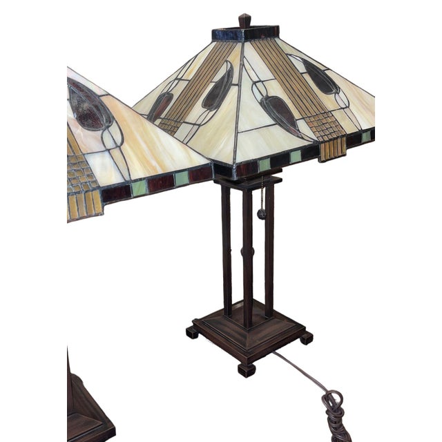 Decorative pair of late 20th century American table lamps in the Arts & Crafts style, each featuring a stained-glass style...