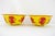 Pair of Chinese imperial yellow Peking glass bowls. Each features foliate lotus-lobed edges and striking carved red floral...